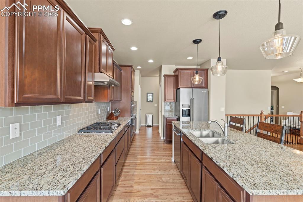 Image 17 of 44: Kitchen featuring a sink, stainless steel appliances, light wood finished f