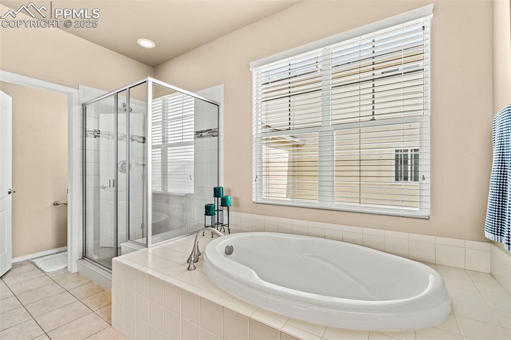 Image 28 of 44: Full bathroom featuring a garden tub, a stall shower, healthy amount of nat