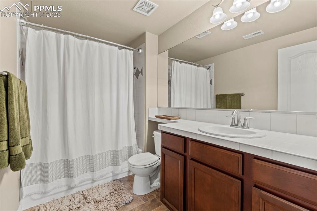 Image 39 of 44: Bathroom featuring vanity, toilet, and shower / bath combination with curta