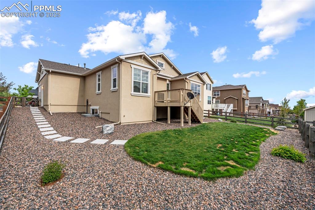 Image 44 of 44: Back of house with stairway, stucco siding, a wooden deck, and a residentia