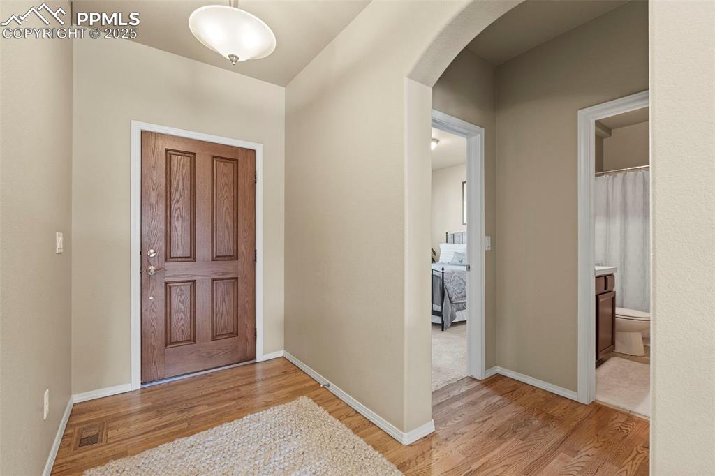 Image 7 of 44: Entryway with arched walkways, light wood-type flooring, and baseboards