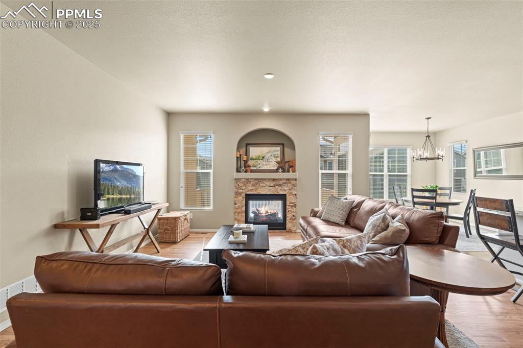 Image 9 of 44: Living area featuring light wood finished floors, a fireplace, baseboards, 