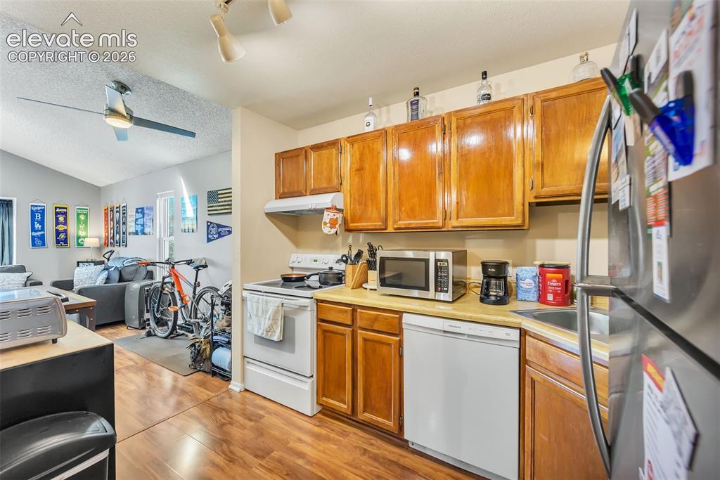 Image 3 of 13: Kitchen with appliances with stainless steel finishes, open floor plan, lig