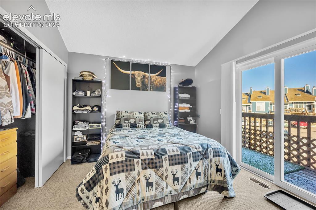 Image 5 of 13: Bedroom featuring light colored carpet, access to exterior, vaulted ceiling