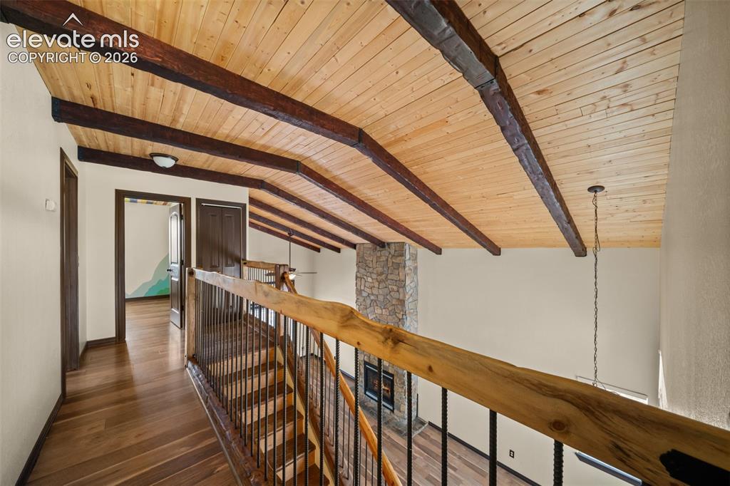 Image 15 of 48: Vaulted wood-finish ceiling with exposed beams, wood-finish flooring, and a