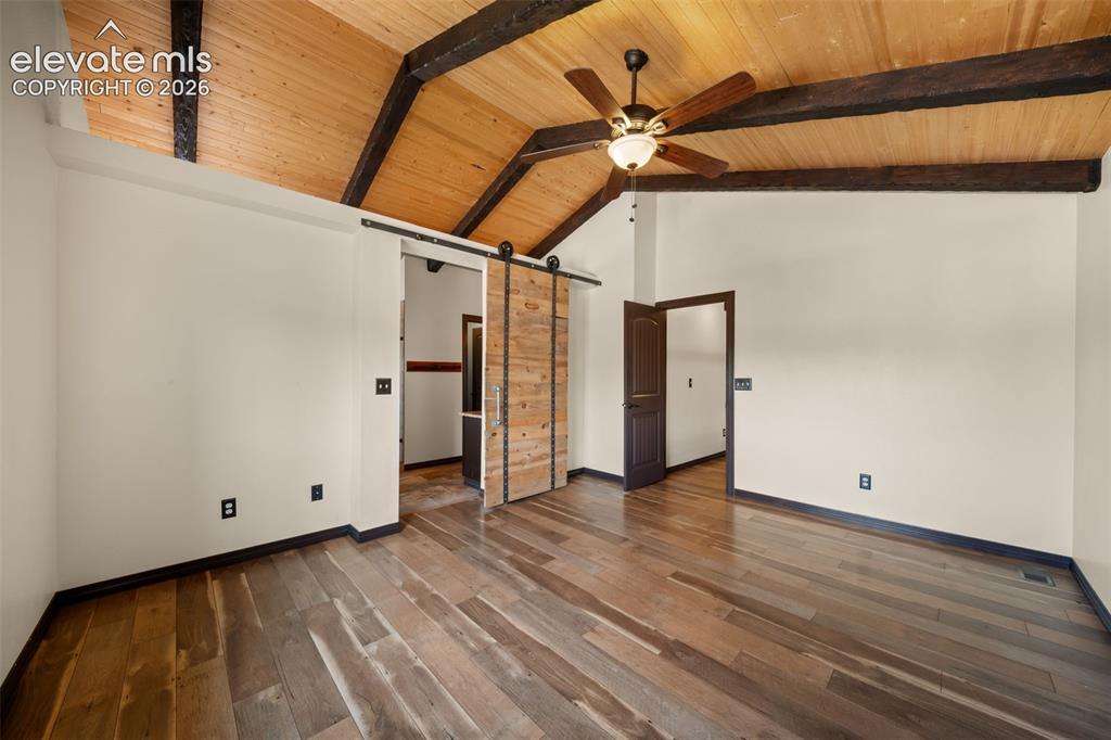 Image 17 of 48: Vaulted wood-paneled ceiling with exposed wood beams, wood-finish flooring,