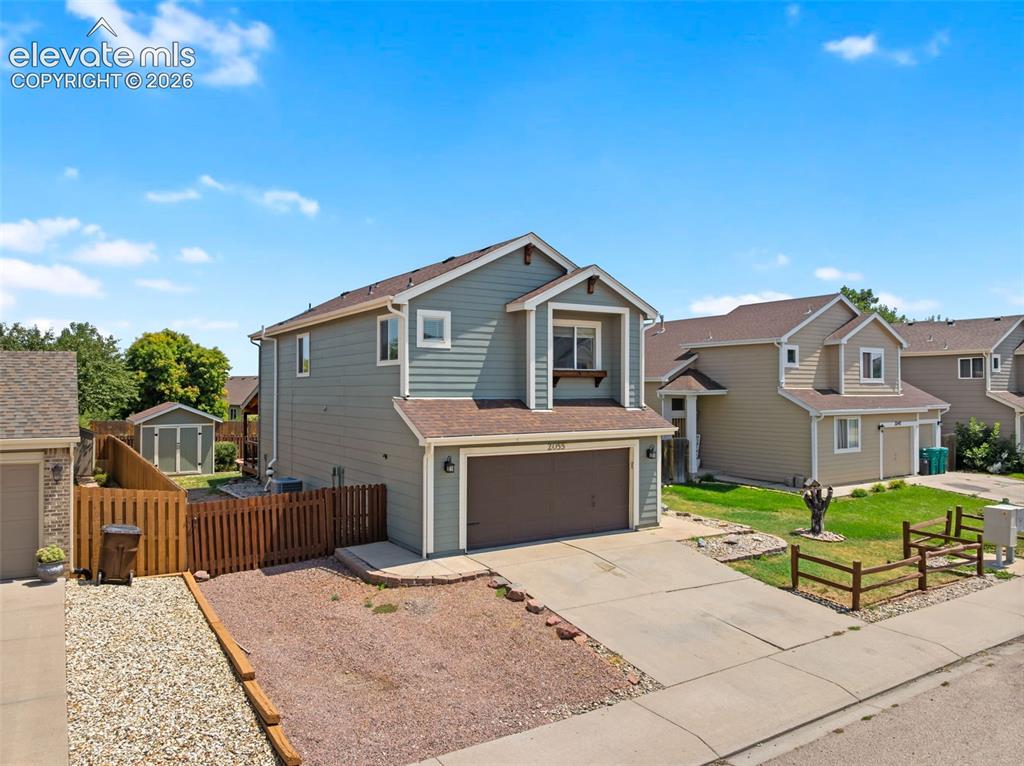 Image 2 of 48: Two-story residence featuring light gray siding, brown shingle roofing, and