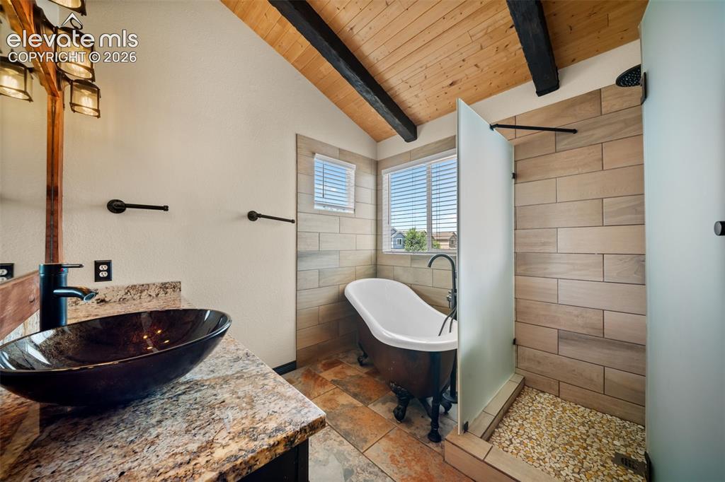 Image 20 of 48: Vaulted wood-plank ceiling with exposed beams, freestanding clawfoot tub, d