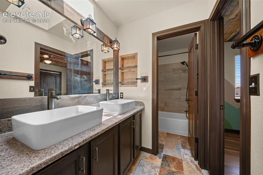 Image 25 of 48: Dual vanity with vessel sinks, granite-finish countertop, dark wood-finish 