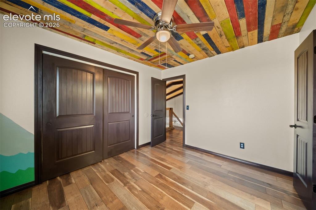 Image 27 of 48: Wood-finish flooring with a multi-colored wood-paneled ceiling