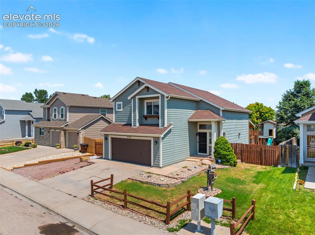 Image 44 of 48: Two-story residence featuring light blue siding and a brown shingle roof