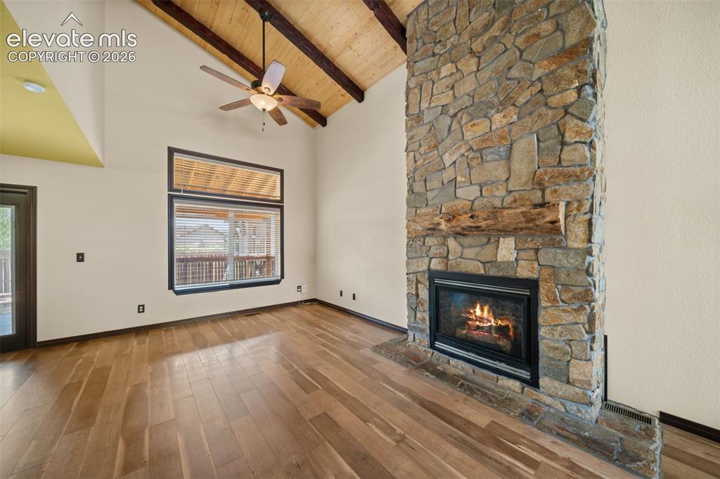 Image 7 of 48: Vaulted wood-paneled ceiling with exposed beams, wood-finish flooring, ston