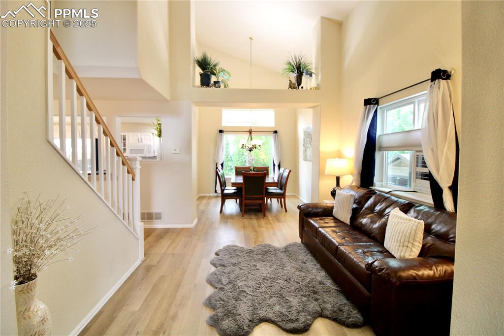 Image 6 of 50: Living room featuring natural light, LVP, and an evaporative cooler