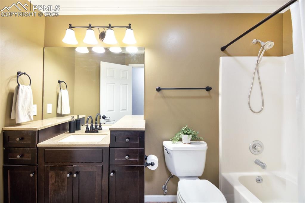 Image 19 of 32: Upper level Full bathroom with stone counter top and warm cabinetry.