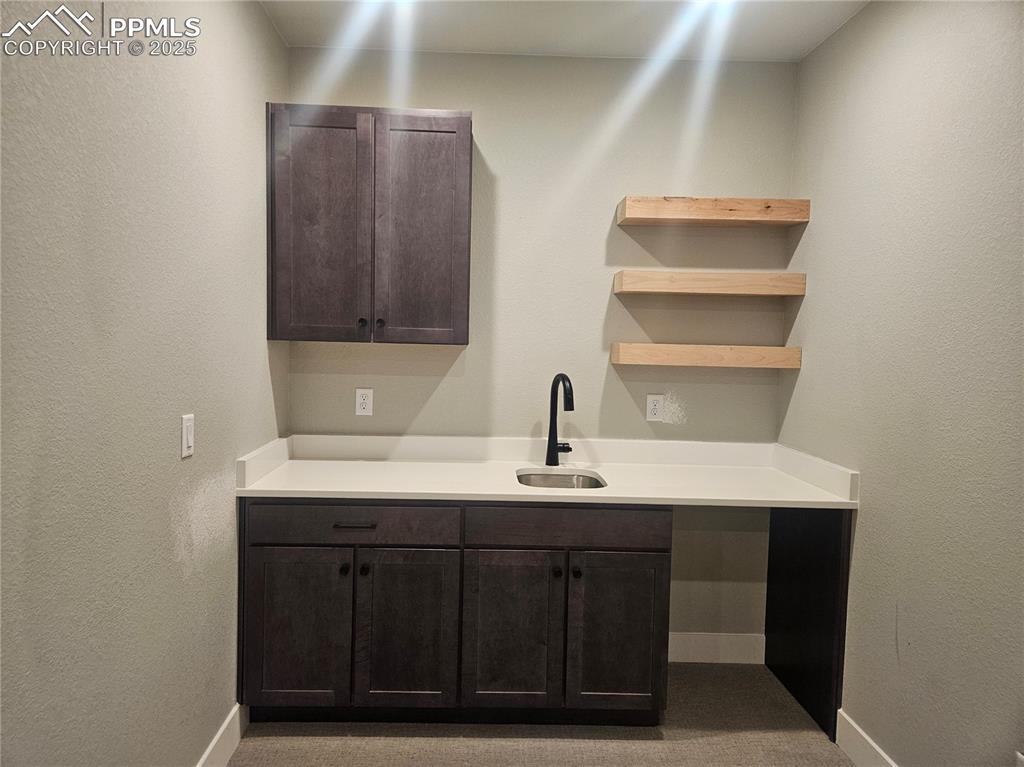 Image 13 of 15: Bar area with a sink, baseboards, and carpet flooring
