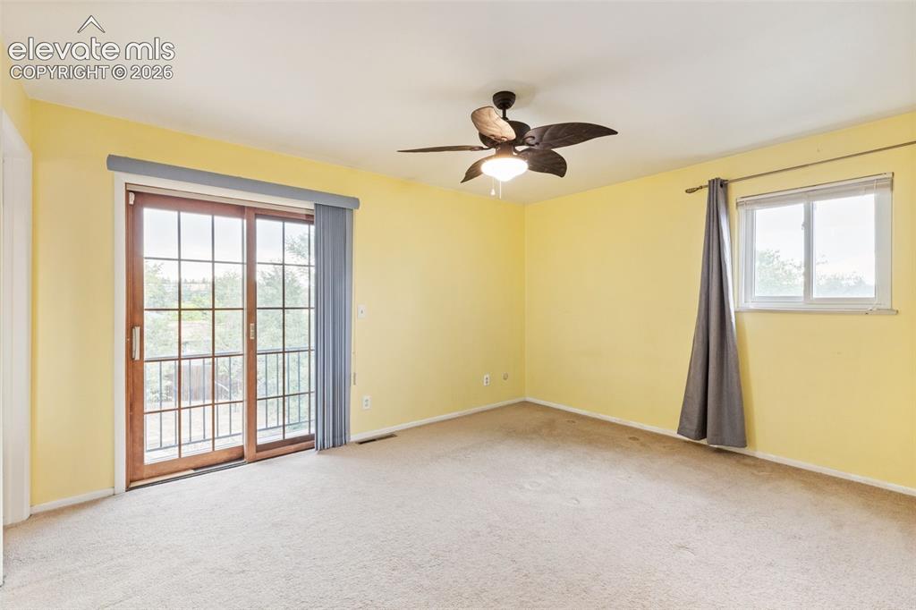 Image 18 of 44: Primary bedroom with sliding door to deck