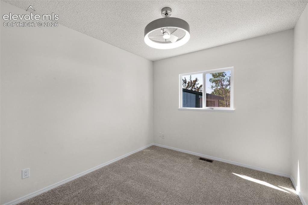 Image 18 of 36: 2nd main level bedroom with new carpet and ceiling light/fan