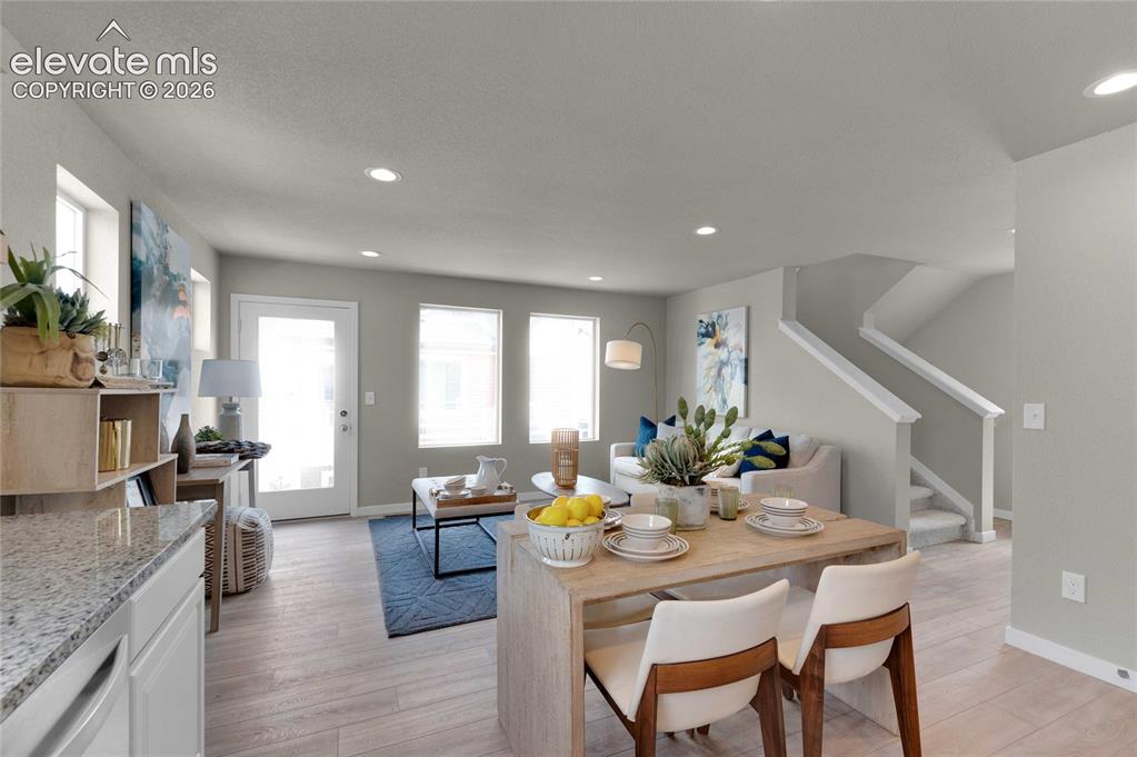 Image 15 of 31: Open-concept living area with wood-finish flooring, recessed lighting, and