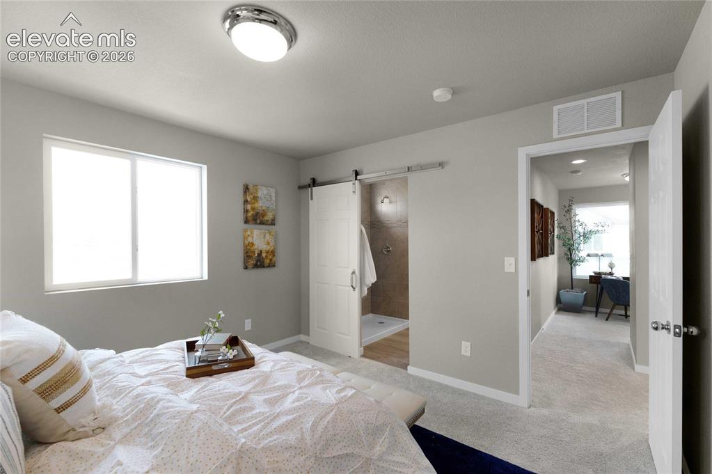 Image 18 of 31: Spacious bedroom featuring light gray walls, plush carpeting, a large doubl
