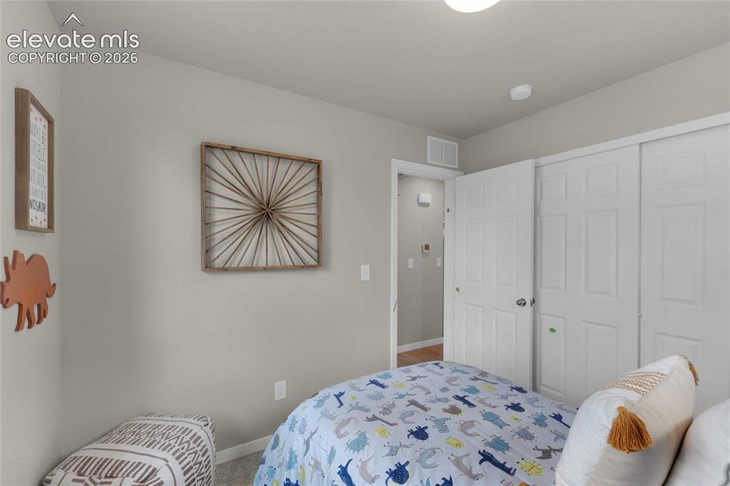 Image 23 of 31: Light gray walls with white baseboards frame a room featuring a carpeted fl