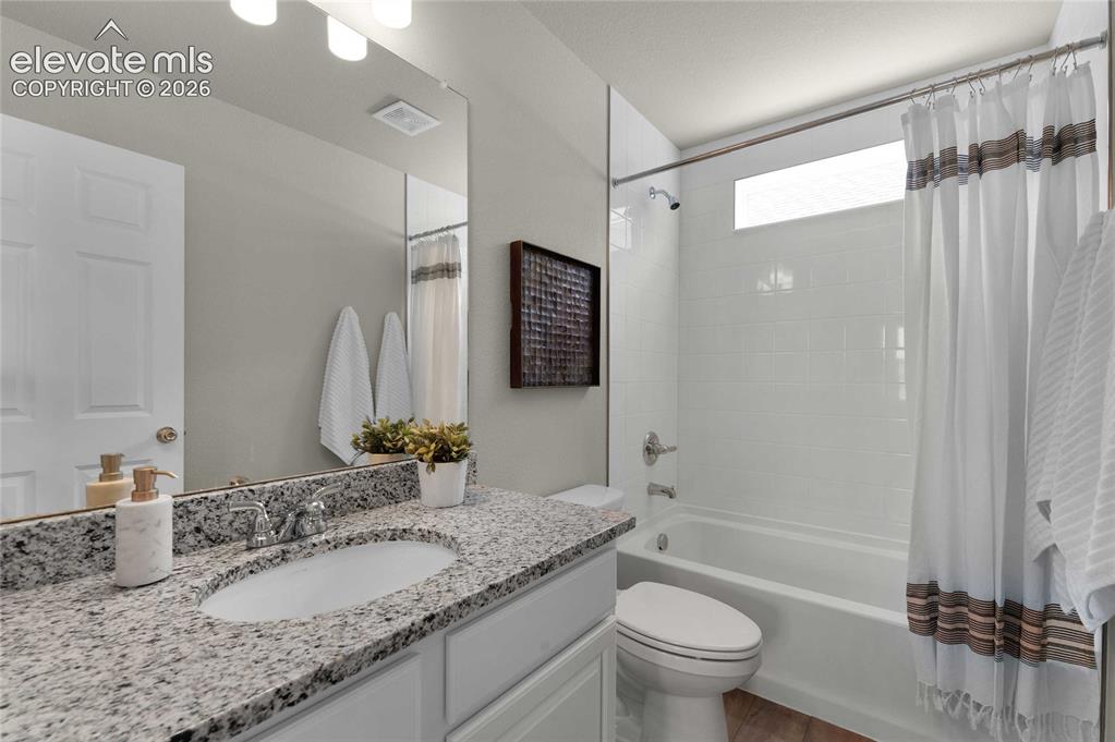 Image 27 of 31: Bathroom featuring a vanity with granite countertop, undermount sink, and c