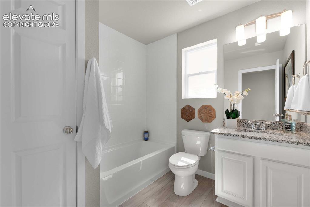 Image 28 of 31: Bathroom featuring a built-in tub with tile surround, a window, a white van