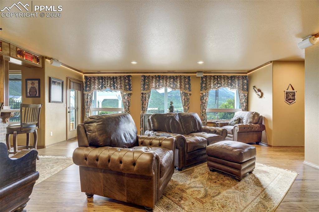 Image 21 of 40: Lower level family room offers a custom wetbar and walkout to the fully lan