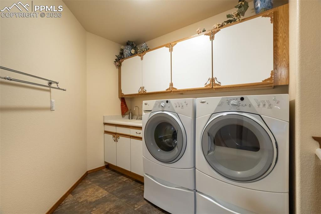 Image 26 of 40: Spacious laundry room with folding counter and cabinetry