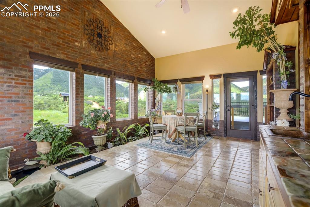 Image 6 of 40: Lovely sun room with views on 3 sides, wet bar, and walkout to the back dec