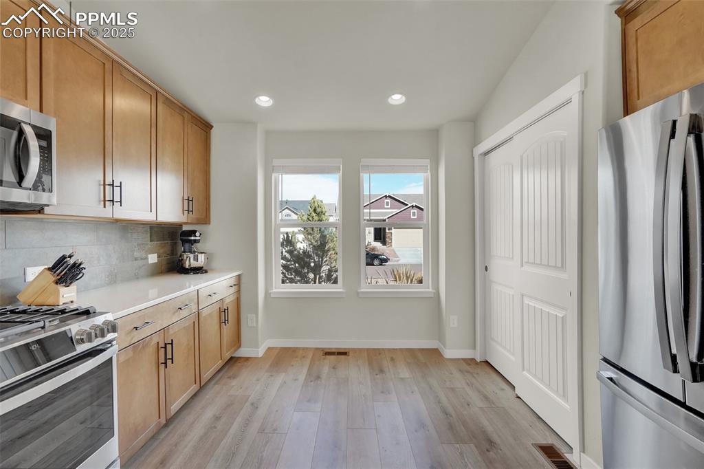 Image 15 of 42: Modern kitchen with quartz counters, gas range, built in microwave, plentif