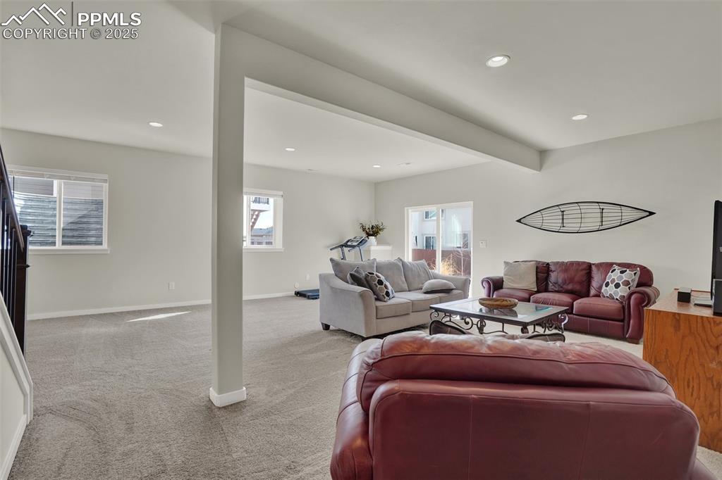 Image 29 of 42: Main living area of basement looking towards the door and backyard.