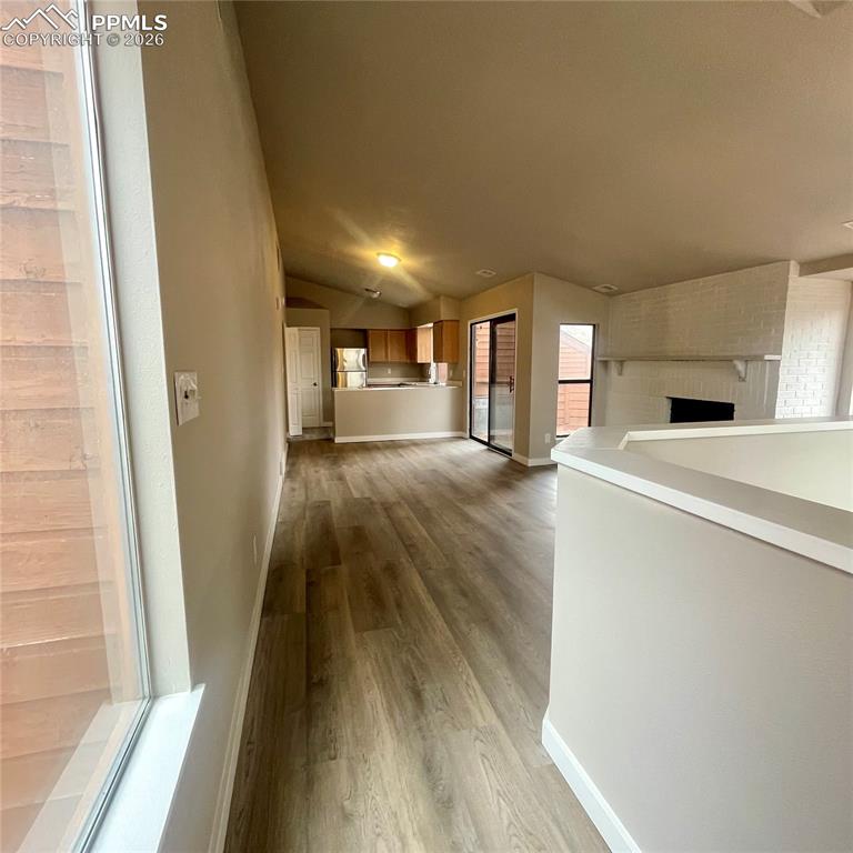 Image 12 of 43: Top of the stairs looking thru Great Room & Dining Area toward Kitchen.