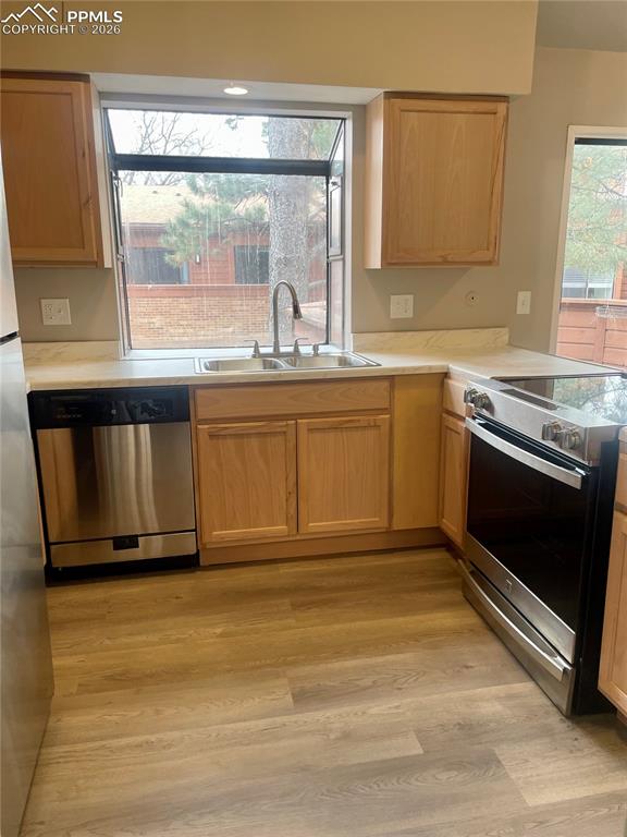 Image 19 of 43: Efficient U-shaped Kitchen has stainless steel appliances, light countertop