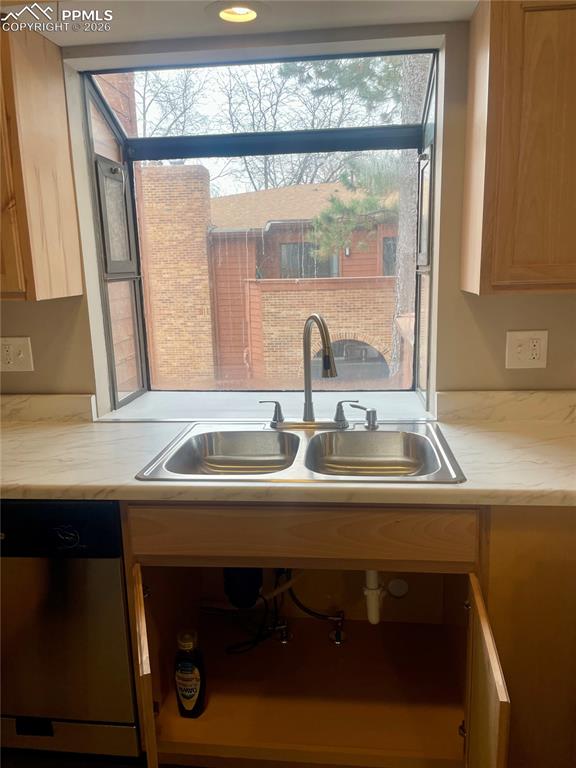 Image 22 of 43: Kitchen has light countertops, stainless steel dishwasher, LOTS of natural