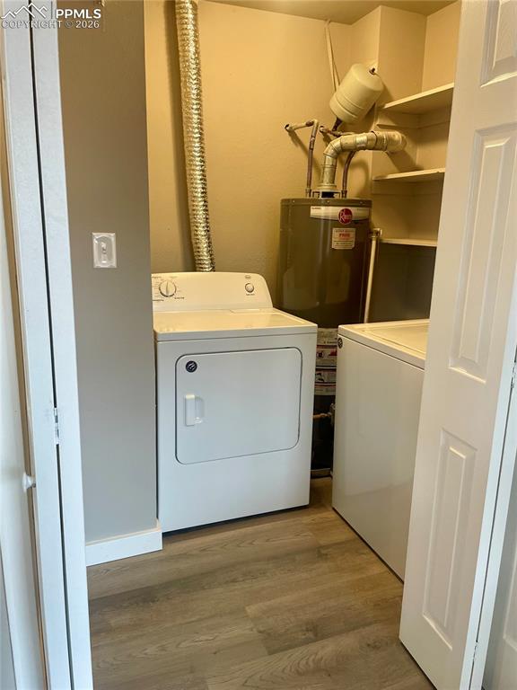Image 29 of 43: Laundry area has LVP flooring, separate washer/dryer, & water heater