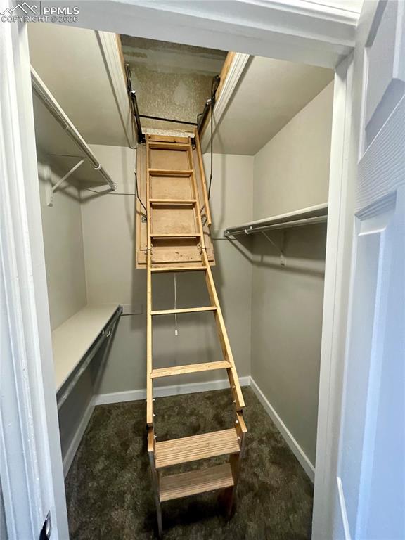 Image 40 of 43: Large walk-in closet has attic access with lots more storage.