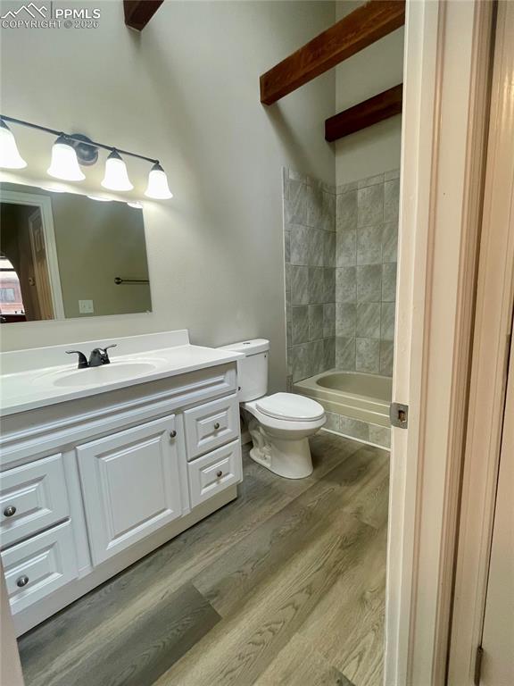 Image 7 of 43: Bathroom with vanity, light wood-style floors, beam ceiling, and bathing tu