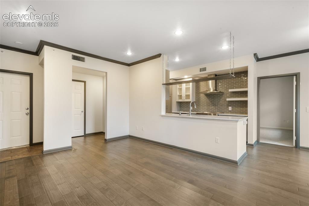 Image 12 of 50: Open-concept kitchen featuring a breakfast bar, stone-finish countertops, s