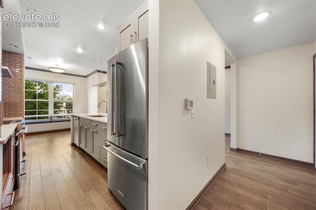 Image 18 of 50: Kitchen featuring stainless steel refrigerator, wood-finish flooring, reces
