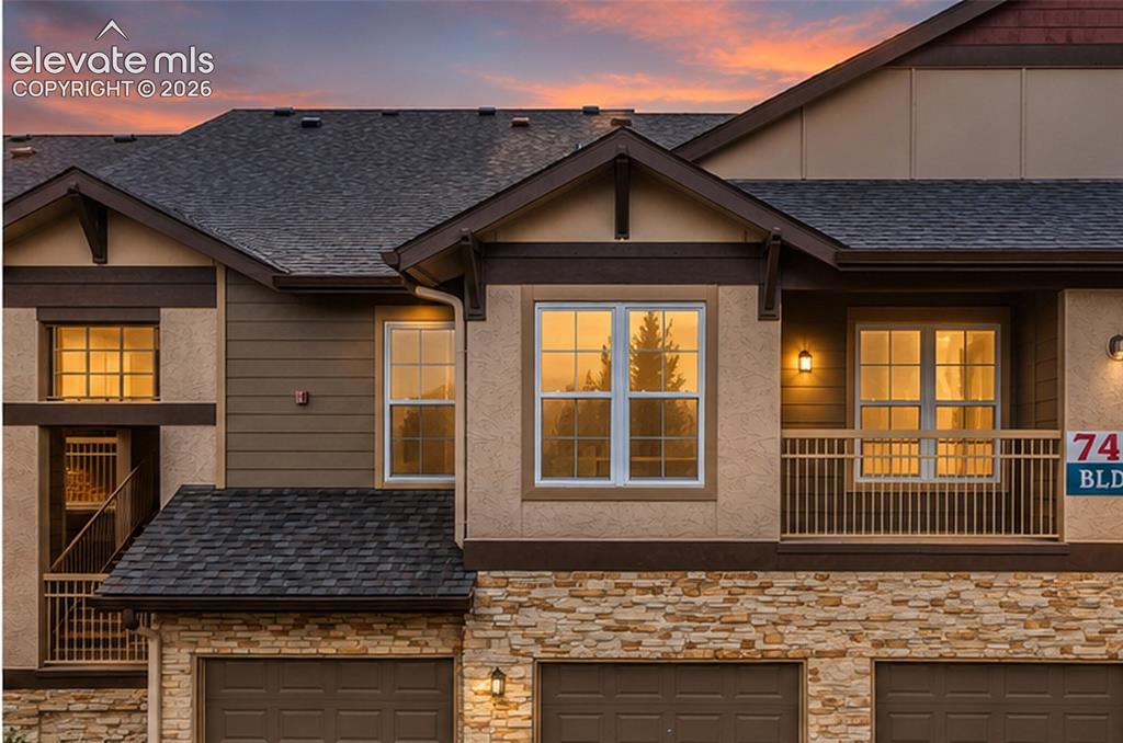Image 2 of 50: Multi-level exterior featuring a stone veneer lower level, horizontal sidin