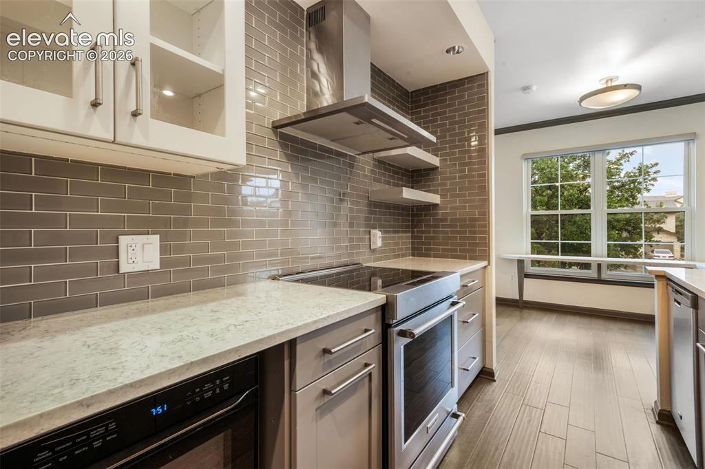 Image 20 of 50: Kitchen featuring light-toned countertops, subway tile backsplash, stainles