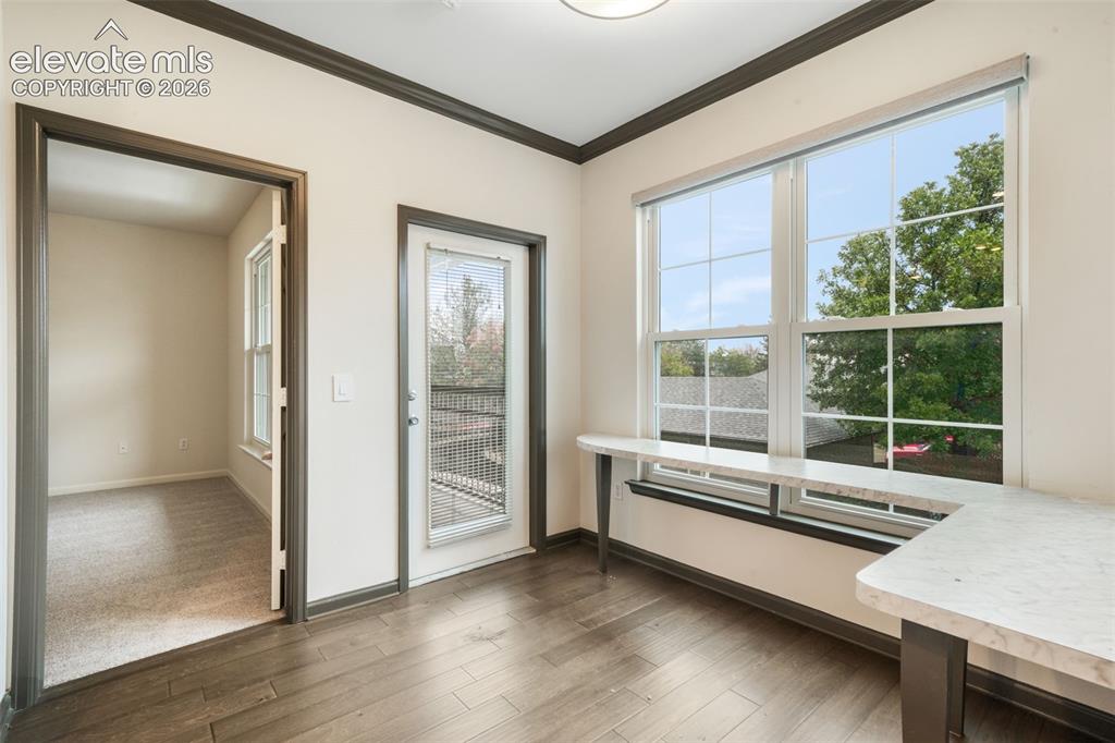 Image 23 of 50: Wood-finish flooring, built-in L-shaped counter with stone-finish surface, 