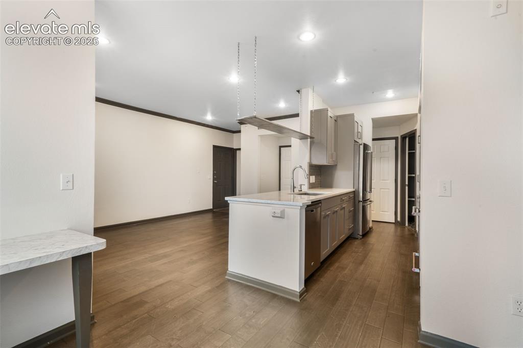 Image 24 of 50: Kitchen island featuring a stone-composite countertop, undermount sink with