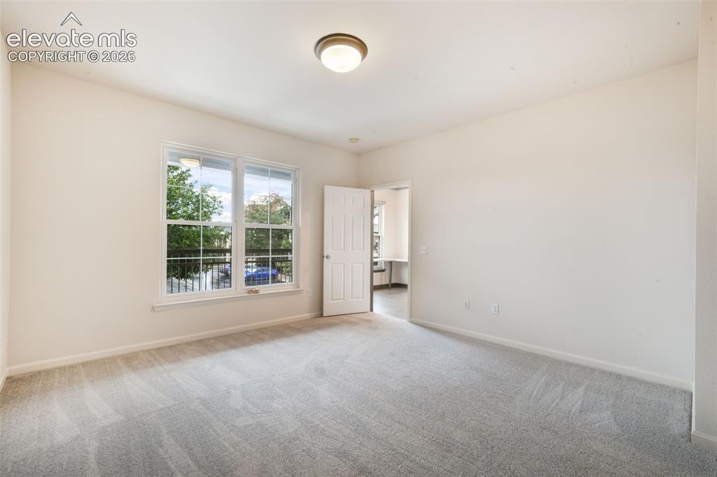 Image 32 of 50: Neutral-toned wall paint, plush carpeting, multi-pane window with exterior