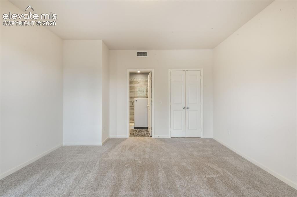 Image 35 of 50: Neutral-toned wall-to-wall carpeting, white interior walls, and dual-panel
