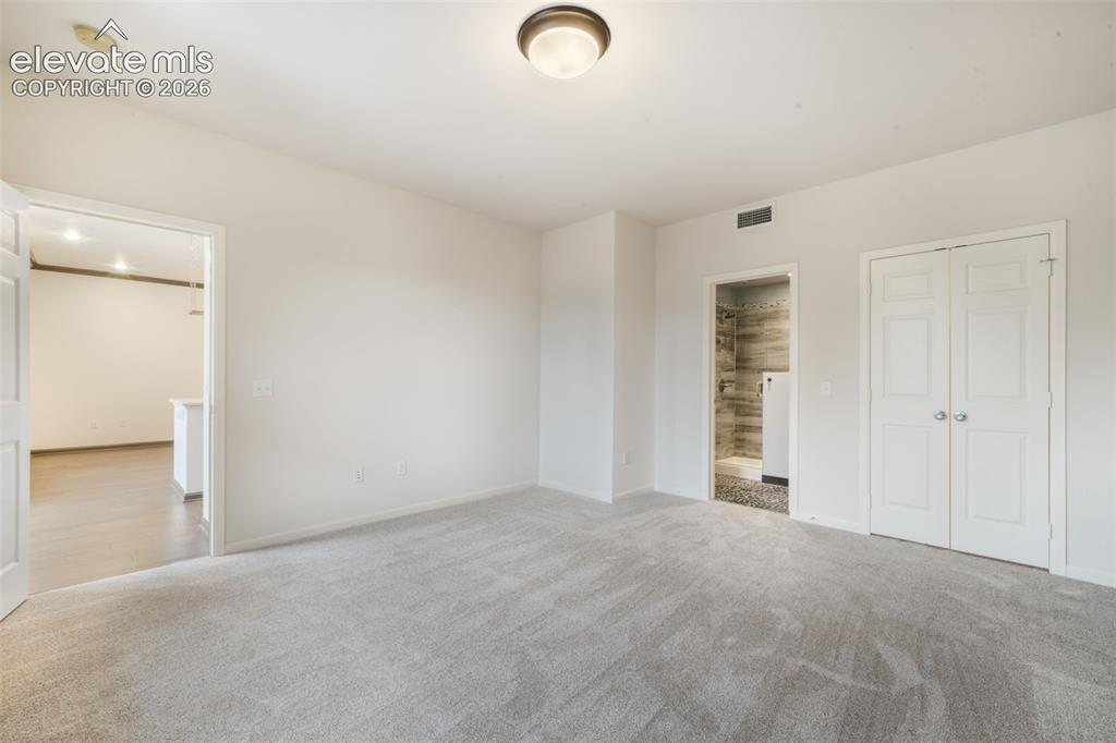 Image 37 of 50: Neutral wall tones, wall-to-wall carpeting, flush-mount ceiling lighting, a