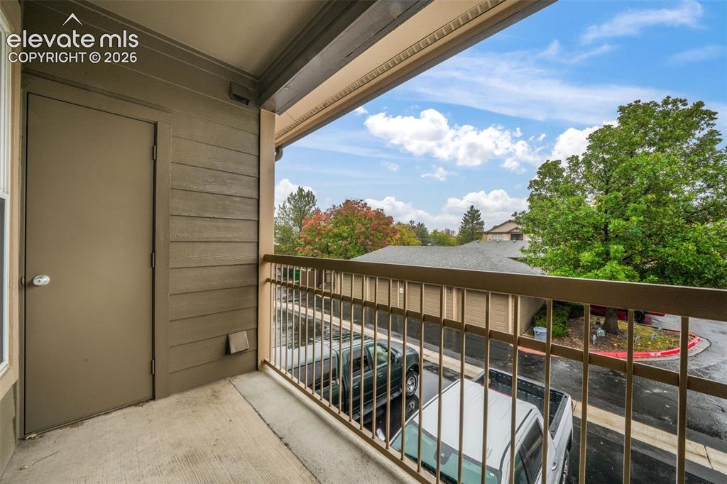 Image 39 of 50: Covered balcony featuring concrete flooring, a solid-panel utility closet d
