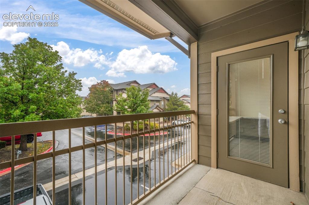 Image 40 of 50: Covered balcony featuring concrete flooring, horizontal lap siding, metal r