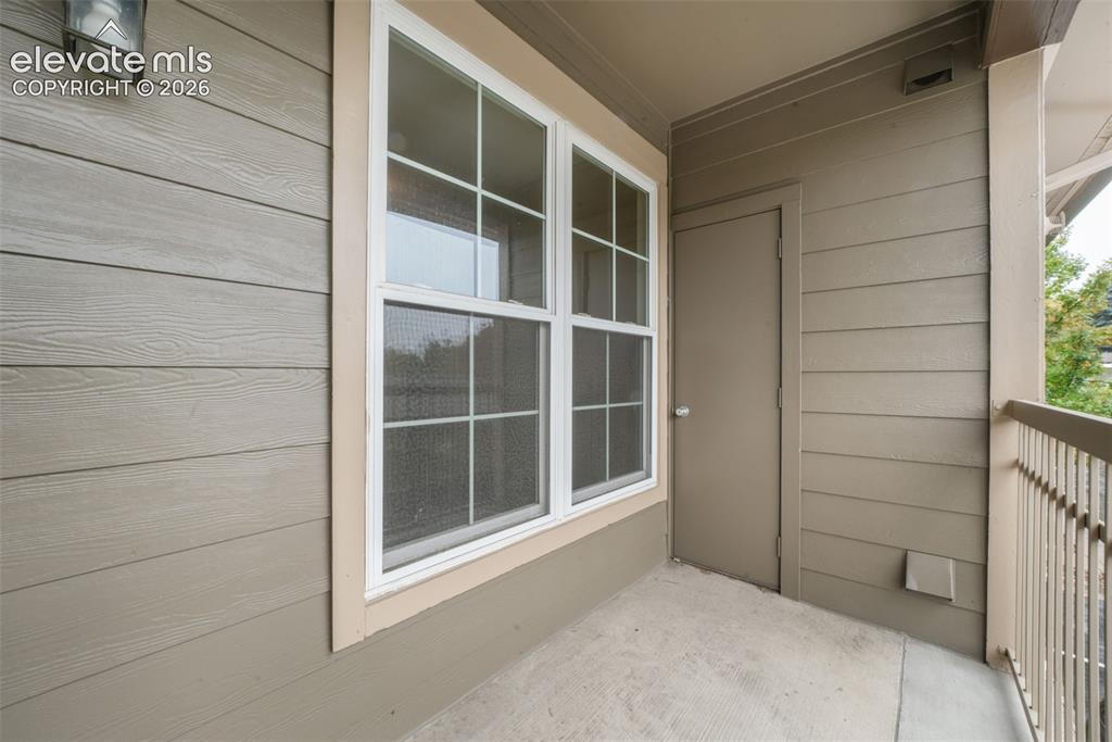 Image 41 of 50: Covered balcony featuring horizontal lap siding, a six-pane double-hung win