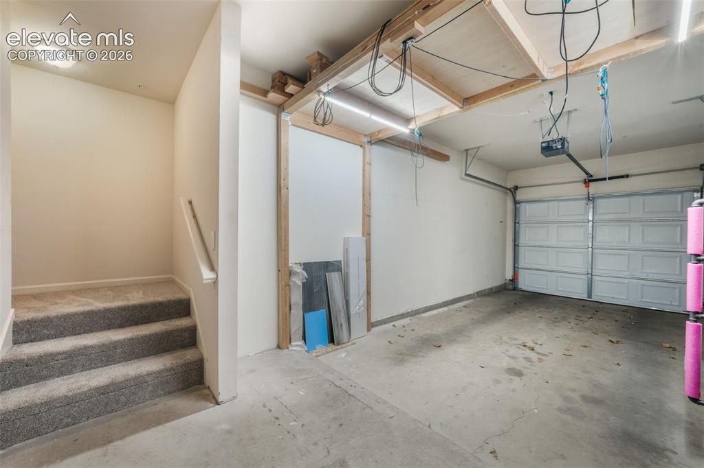 Image 42 of 50: Garage featuring a concrete floor, a paneled overhead garage door, built-in